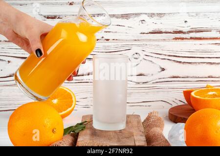 Orange juice pouring from the bottle into the glass Stock Photo