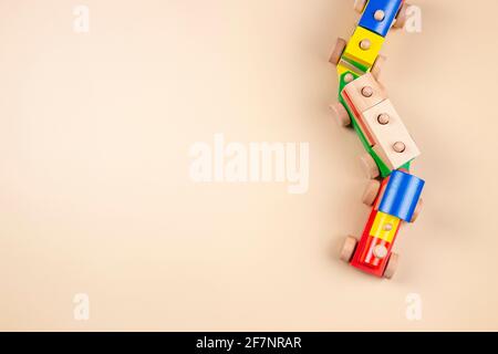 Wooden toy train with multi colored blocks on pastel beige background. Top view Stock Photo