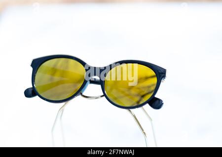 Fashion cat eye sunglasses for ladies with big round yellow lenses and black frame shoot outside in a sunny day closeup. Selective focus  Stock Photo