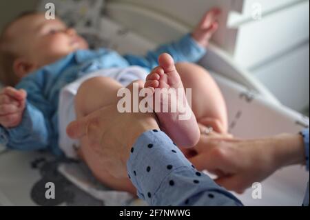 Mother changing diapers of cute little baby boy Stock Photo