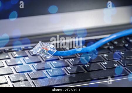 Internet LAN cable on a computer keyboard symbolizing cyberspace and connectivity Stock Photo