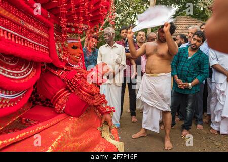 Kannur, India - December 2, 2019: Theyyam artist perform during temple festival in Kannur, Kerala, India. Theyyam is a popular ritual form of worship Stock Photo