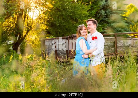 Happy and in love. Young Couple Embracing on meadow field in a village. Stock Photo