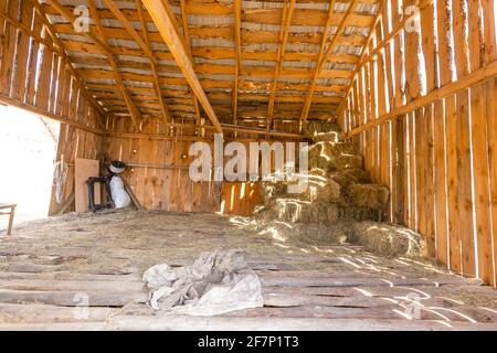 Photo inside a barn with light streaming in through siding. Stock Photo