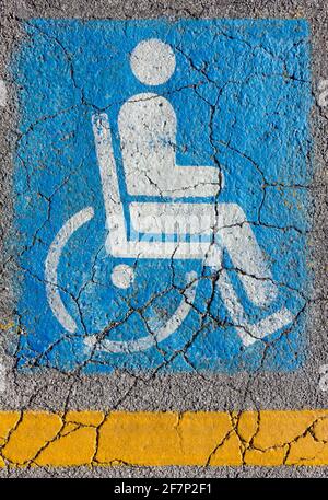 International access sign on a cracked asphalt with a yellow strip below Stock Photo