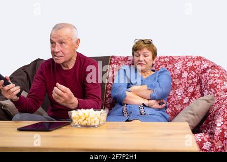 Senior family couple sport fans watching football on TV. Elderly husband having fun celebrating victory at home on sofa. Stock Photo