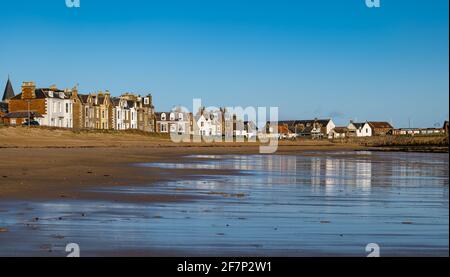 North Berwick, East Lothian, Scotland, United Kingdom. 9th Apr, 2021. UK Weather: the seaside houses are reflected in the wet sand of East Beach at low tide just after sunrise on a beautiful cold sunny Spring morning with blue sky Stock Photo