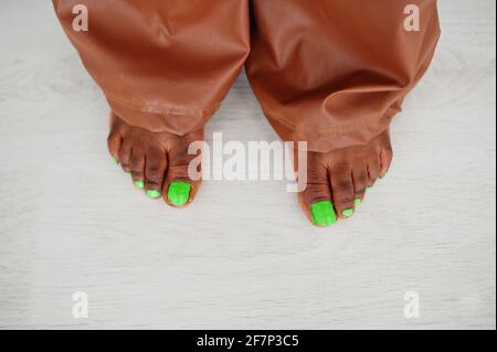 Fingers on legs with green pedicure. Beauty afro american model fashion brazilian woman. Stock Photo