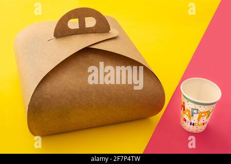 Packaging box with handle mockup for cake and birthday paper cup on yellow and pink background Stock Photo