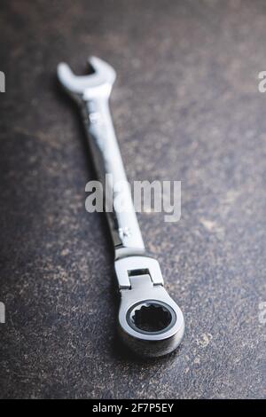 Stainless steel ratchet wrench on black table. Stock Photo
