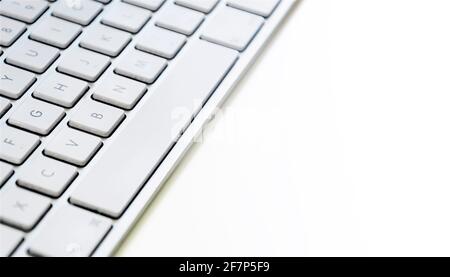 Modern computer keyboard with white keys. Side view with copy space on white background Stock Photo