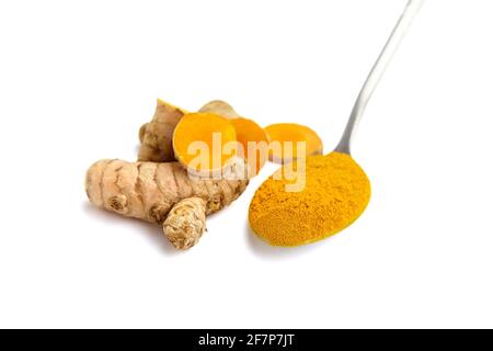 Curcuma roots and powder in spoon isolated on white background. Halved turmeric rhizome. Oriental spice Stock Photo
