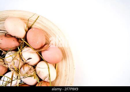 natural Easter decoration, eggs on a plate with feathers and straw Stock Photo