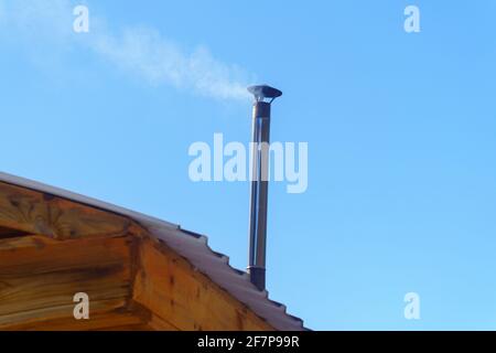 Dense Smoke Rises From the Chimney. Village old house. Rural Scene. selective focus Stock Photo