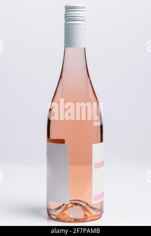 Beautiful burgundy style bottle of rose wine on white surface and background Stock Photo