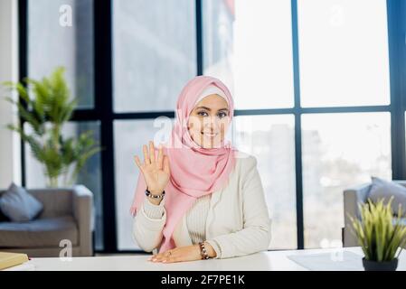 Close up portrait of smiling arab woman, CEO looking at camera, happy female boss, posing, making headshot picture for company photoshoot, successful woman at work, in traditional muslim clothing Stock Photo