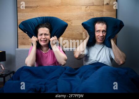 Loud Neighbor Making Noisy Party While Couple Sleeping In Bed Stock Photo