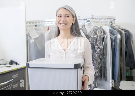 Joyful woman with container in hands Stock Photo