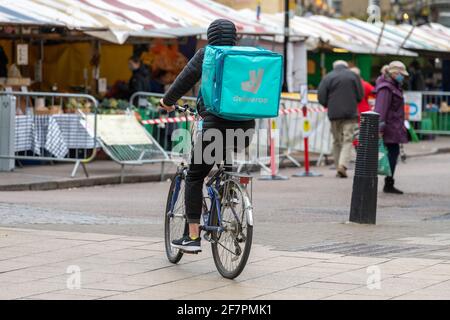 A rear view of a deliveroo delivery person on a bicycle in Cambridge city UK Stock Photo