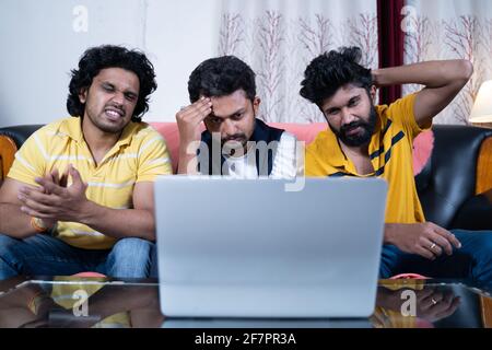 young sport fans upset over lose of supporting team while watching live streaming match on laptop at home. Stock Photo