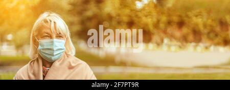 Coronavirus, COVID-19 Pandemic concept. Blonde woman in wearing face mask protective for disease virus SARS-CoV-2 at the city street Stock Photo