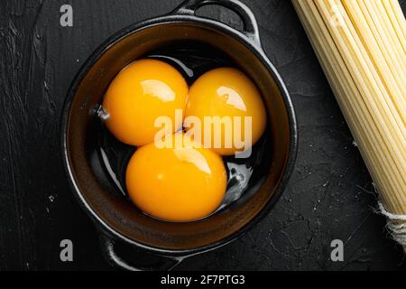 Bright yellow egg yolks set, on black stone background, top view flat lay Stock Photo