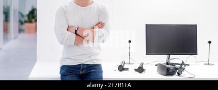 Digital designer standing near computer and virtual reality headset on white table Stock Photo