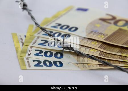 200 euro banknotes fanned with barbed wire and isolated on white Stock Photo