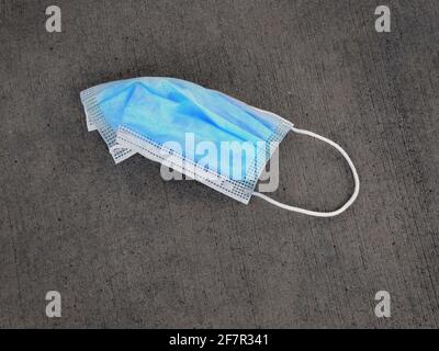 Discarded facemask face mask for Covid Coronavirus garbage trash Stock Photo