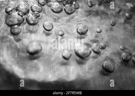 Closeup of many bubbles moving through water on metalic surface Stock Photo