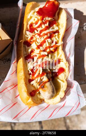 Girl is holding take away Cheese Hot Dog Stock Photo