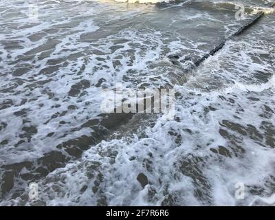 Breaking waves on a wooden breakwater on the Baltic Sea coast. Stock Photo