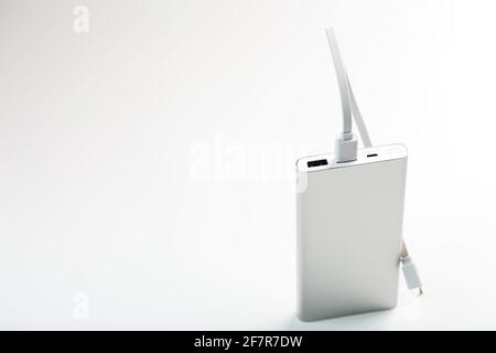 Powerbank for charging mobile devices with cable, on a white background. Universal external battery for gadgets. Isolate Stock Photo