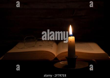 Book by candle light Stock Photo