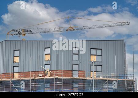 A Crane and workers on a construction site or building site Stock Photo