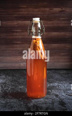 Isolated bottle of homemade kombucha, a brew fruit tea with probiotic,bacteria and yeast. Second fermentation with strawberries and mint with vintage Stock Photo