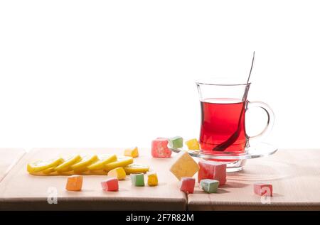 Traditional turkish tea, lemon and delight on the wooden table, isolated on a white background Stock Photo