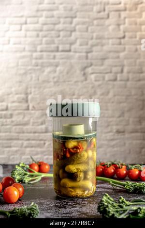 Retro food photography of a press jar with homemade fermented pickles and vegetables. Still life image with a vintage look. Stock Photo