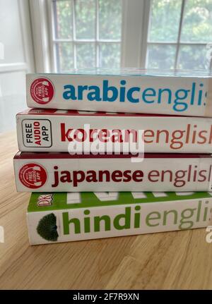 A stack of bilingual phrase books and dictionaries - Arabic, Korean, Japanese, and Hindi - borrowed from the library. Stock Photo