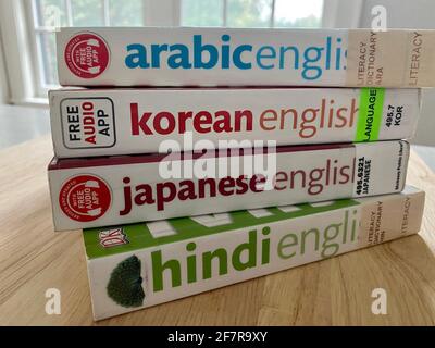 A stack of bilingual phrase books and dictionaries - Arabic, Korean, Japanese, and Hindi - borrowed from the library. Stock Photo