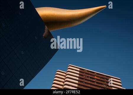 Slanted low angle view of the end of the Asahi Flame at sunset, Sumida, Tokyo, Japan Stock Photo