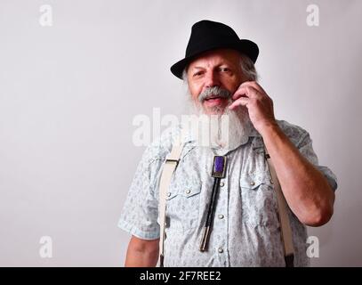 Delighted senior Caucasian bearded male stroking his beard Stock Photo