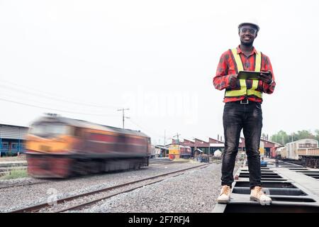 African engineer   control a the train on railway with using tablet Stock Photo
