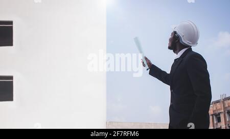 African engineer manager architect looking at construction project Stock Photo