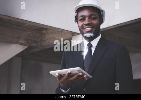African engineer manager architect looking at construction project with using tablet Stock Photo