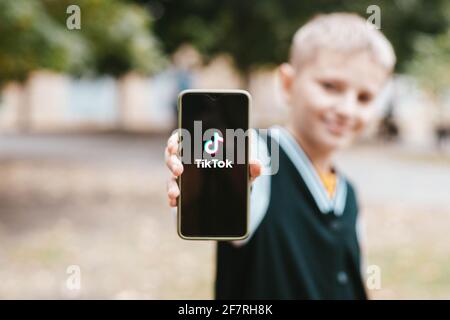 Podolsk, Ukraine - March 29, 2021: Boy holding smartphone with social Internet service Tik Tok on the screen. Tiktok social network. logo of the Stock Photo