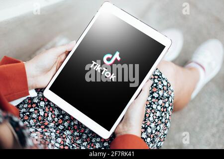 Podolsk, Ukraine - March 29, 2021: Woman hands holding digital tablet with Tiktok social network logo of the current app Stock Photo