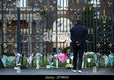 A man stands outside Hillsborough Castle, as people bring flowers, after Britain's Prince Philip, husband of Queen Elizabeth, died at the age of 99, in Hillsborough, Northern Ireland, April 9, 2021. REUTERS/Jason Cairnduff
