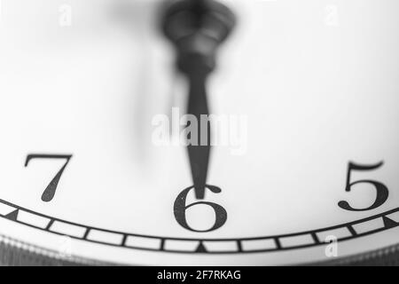 Clock hand pointing six o'clock on white clock face of Twin bell classic alarm clock Stock Photo