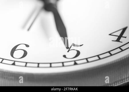 Clock hand pointing five o'clock on white clock face of Twin bell classic alarm clock Stock Photo